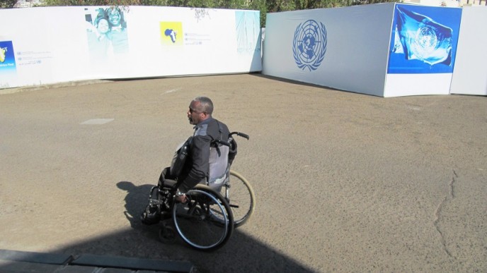 Pyörätuolissa istuva afrikkalainen mies YK:n alueella ILOn toimistossa