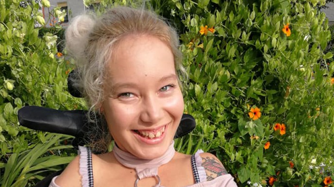 Hymyilevä Vilma Kurran-Kuusela istuu pyörätuolissa.